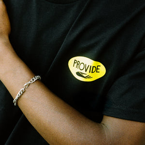 Close up of model wearing Provide's black and yellow T-shirt.