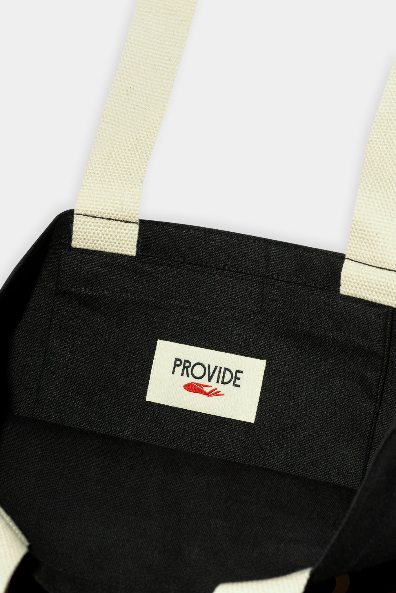 Provide Built on Art and Industry black Tote Bag with hand logo (close up)